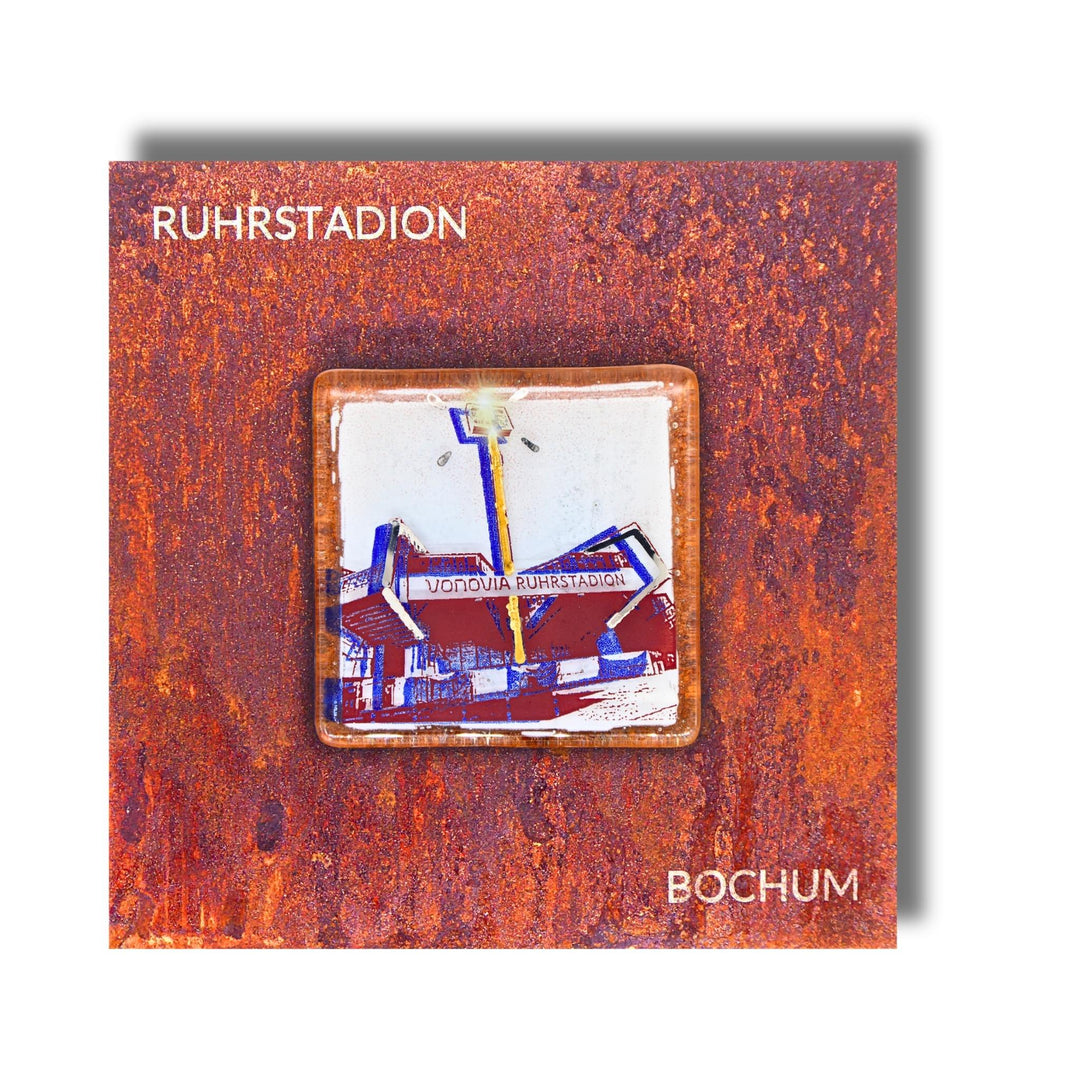 Edition 10/12. Pott Glas Wand-Potträt mit Ruhrstadion-Motiv in Blau. Foto in Schmelzglas auf Roststahl. Quadratisches Format mit Gravur „Ruhrstadion Bochum“.