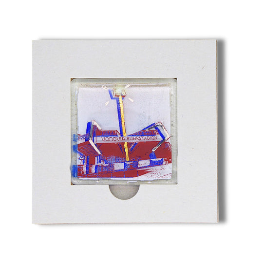 Bochum Edition 10/12. Offenes POTT GLAS Karten-Inlay mit quadratischer Aussparung und Entnahmeaussparung. Darin ein Magnet-POTTRÄT aus Schmelzglas mit blauem Ruhrstadion-Motiv sowie Akzenten aus 24-Karat-Flüssiggold und Platin.
