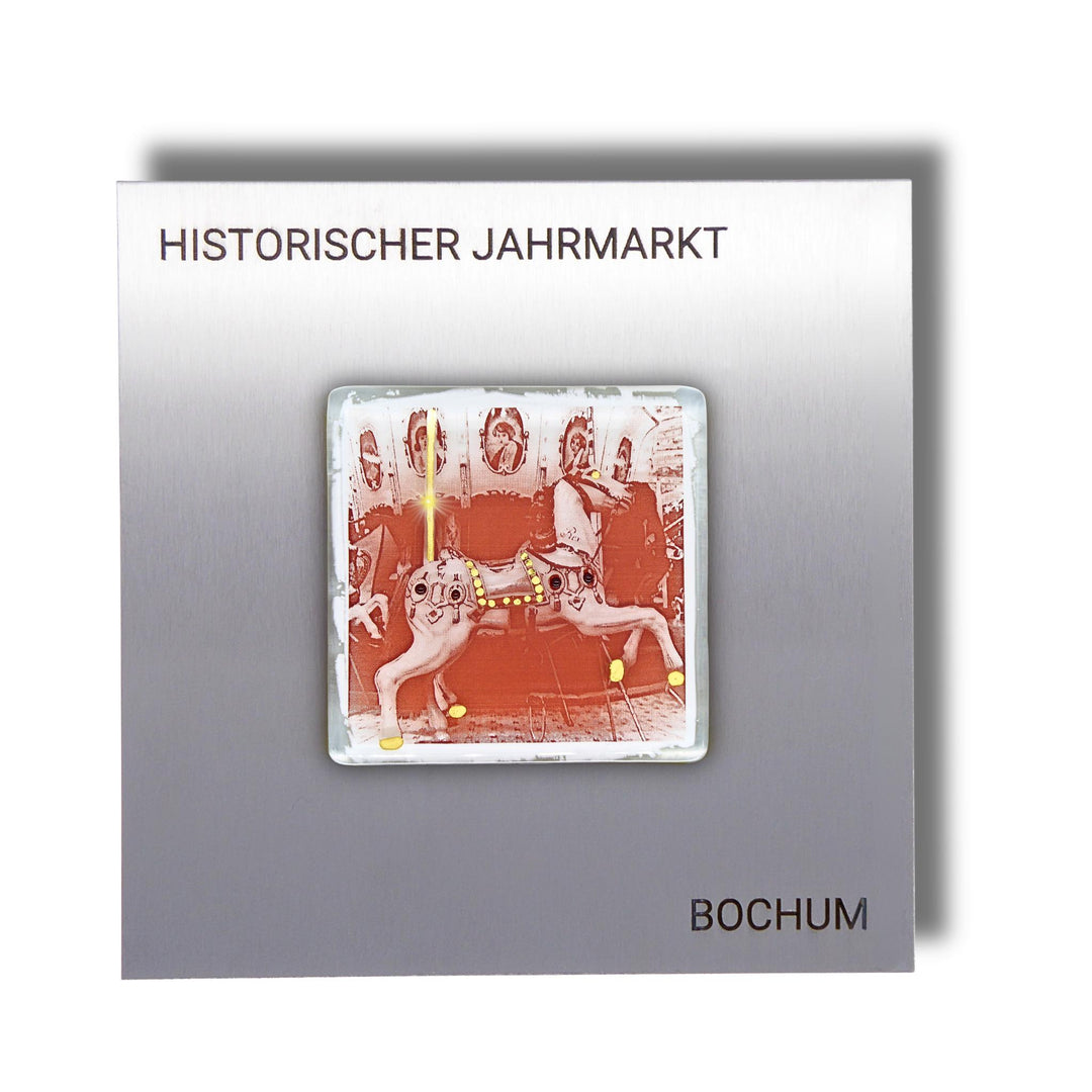 Edition 3/12. Pott Glas Wand-Potträt mit Karussellpferd-Motiv in Eisenrot mit Gold Akzenten. Foto in Schmelzglas auf Edelstahl. Quadratisches Format mit Gravur „Historischer Jahrmarkt Bochum“.