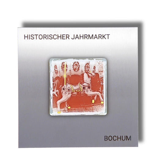 Edition 3/12. Pott Glas Wand-Potträt mit Karussellpferd-Motiv in Eisenrot mit Gold Akzenten. Foto in Schmelzglas auf Edelstahl. Quadratisches Format mit Gravur „Historischer Jahrmarkt Bochum“.