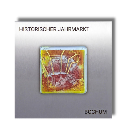 Edition 3/12. Pott Glas Wand-Potträt mit Karussellschwan-Motiv in Gelb mit Gold und Platin Akzenten. Foto in Schmelzglas auf Edelstahl. Quadratisches Format mit Gravur „Historischer Jahrmarkt Bochum“.