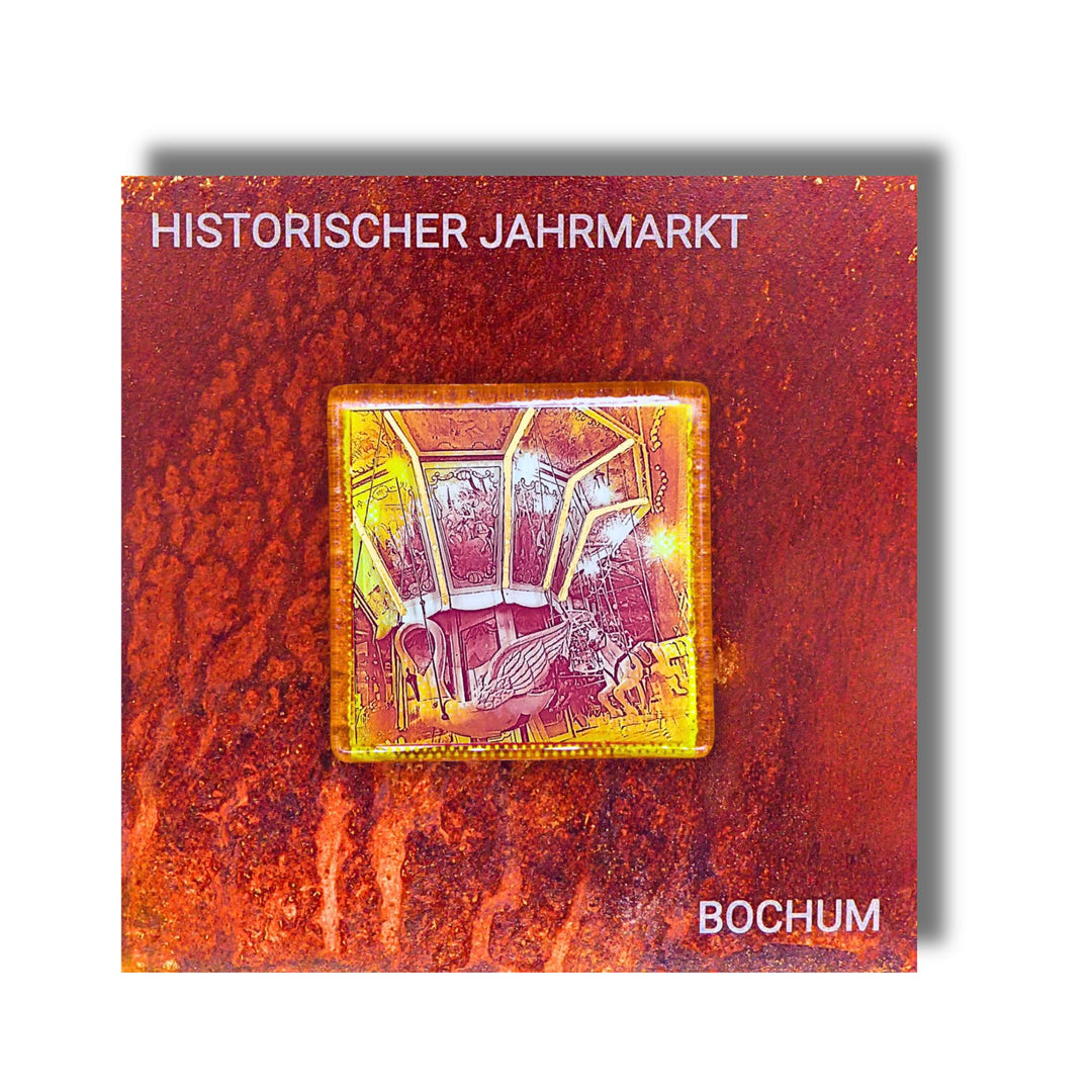 Edition 3/12. Pott Glas Wand-Potträt mit Karussellschwan-Motiv in Gelb. Foto in Schmelzglas auf Roststahl. Quadratisches Format mit Gravur „Historischer Jahrmarkt Bochum“.