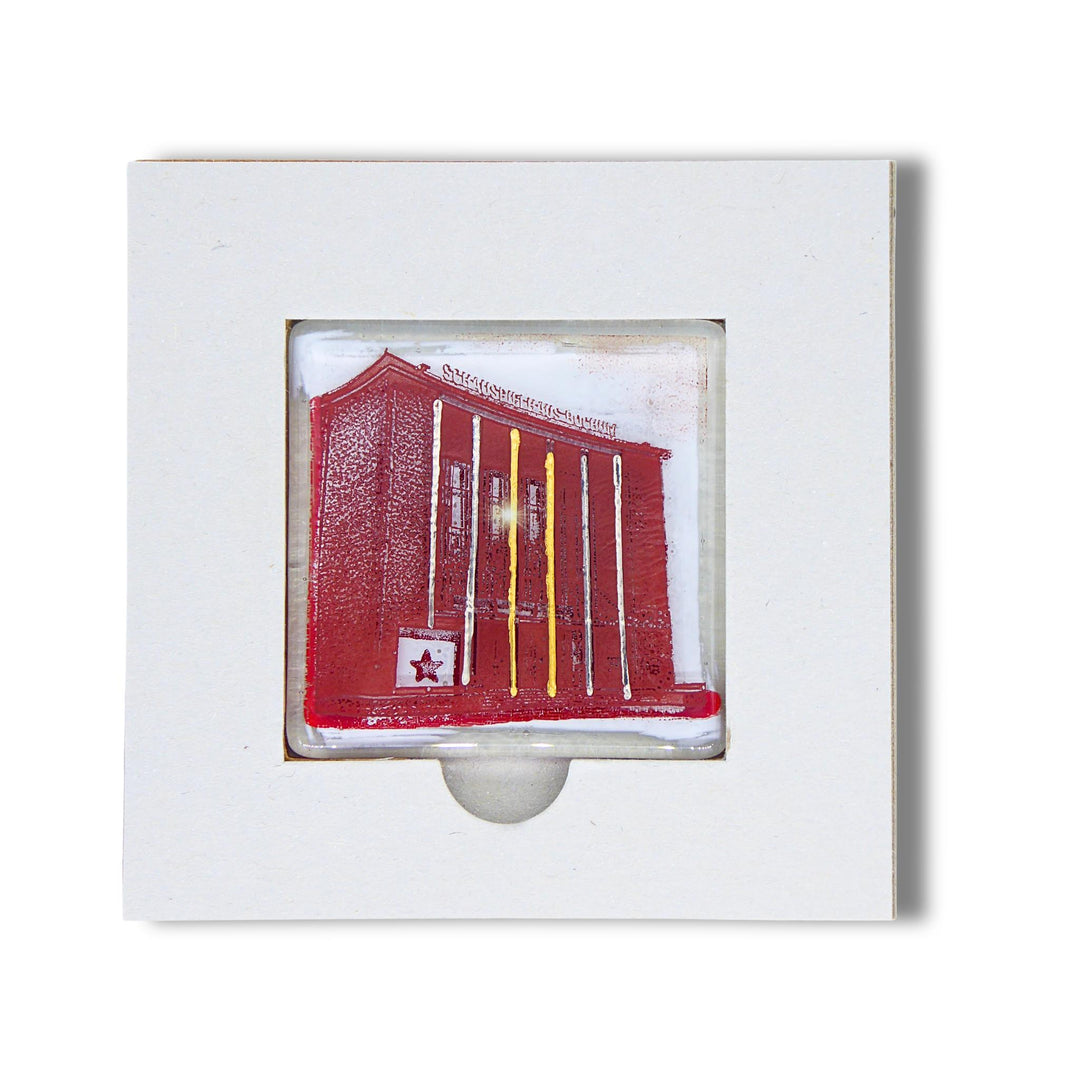 Bochum Edition 04/12. Offenes POTT GLAS Karten-Inlay mit quadratischer Aussparung und Entnahmeaussparung. Darin ein Magnet-POTTRÄT aus Schmelzglas mit Schauspielhaus-Motiv in Rot sowie Akzenten aus 24-Karat-Flüssiggold und Platin.