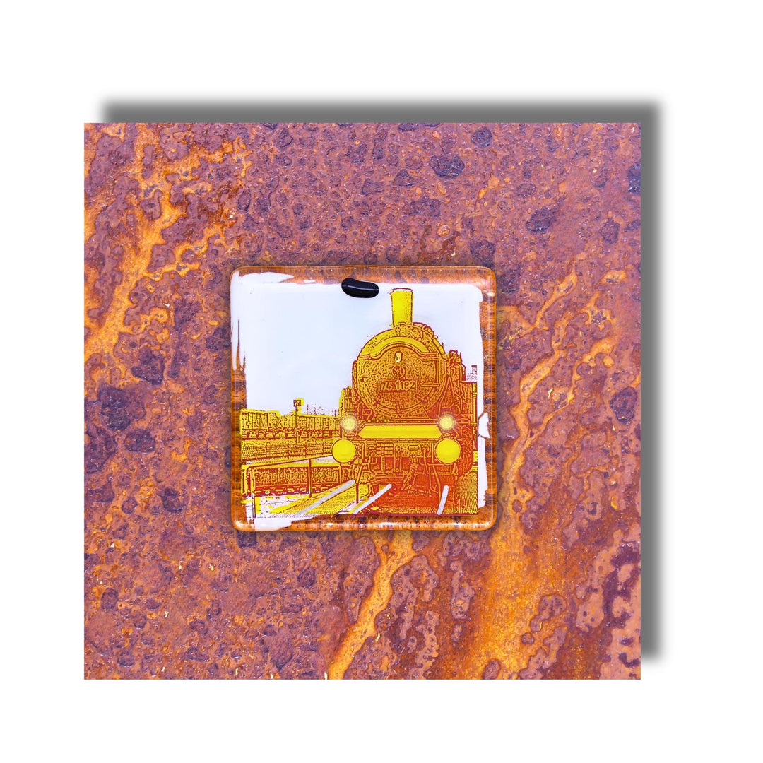 Edition 5/12. Pott Glas Wand-Potträt mit Dampflok-Motiv in Gelb. Foto in Schmelzglas auf Roststahl. Quadratisches Format ohne Gravur.