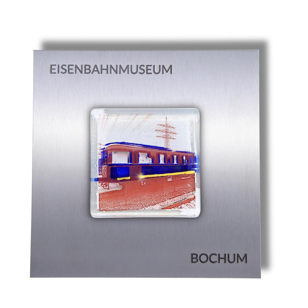 Edition 5/12. Pott Glas Wand-Potträt mit Railflex-Motiv in Blau. Foto in Schmelzglas auf Edelstahl. Quadratisches Format mit Gravur „Eisenbahnmuseum Bochum“.