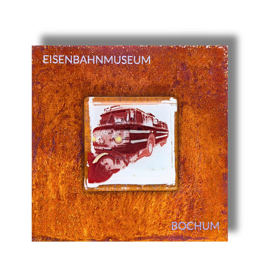 Edition 5/12. Pott Glas Wand-Potträt mit Schi-Stra-Bus-Motiv in Rot. Foto in Schmelzglas auf Roststahl. Quadratisches Format mit Gravur „Eisenbahnmuseum Bochum“.