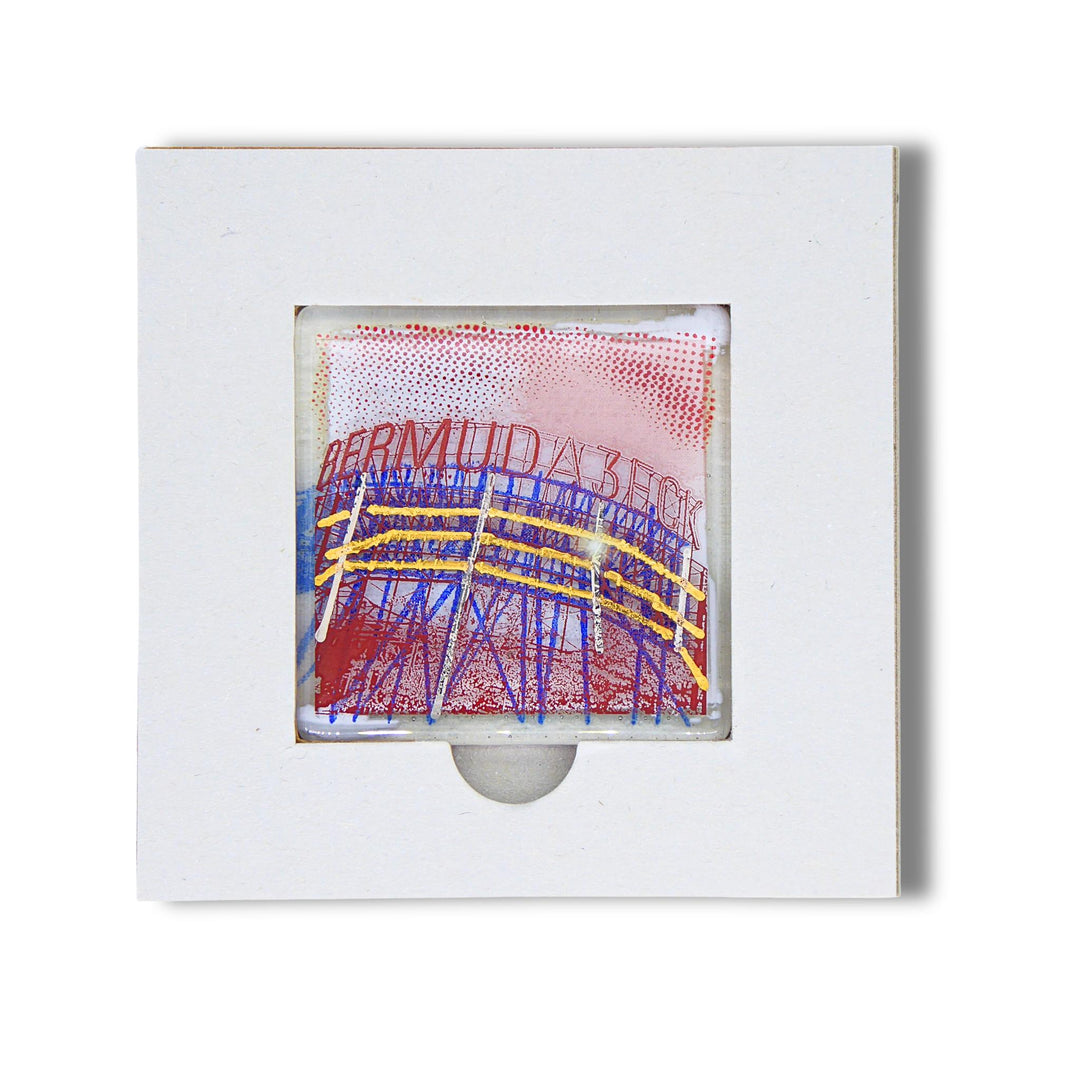Bochum Edition 06/12. Offenes POTT GLAS Karten-Inlay mit quadratischer Aussparung und Entnahmeaussparung. Darin ein Magnet-POTTRÄT aus Schmelzglas mit blau-rotem Bermudadreieck-Motiv sowie Akzenten aus 24-Karat-Flüssiggold und Platin.