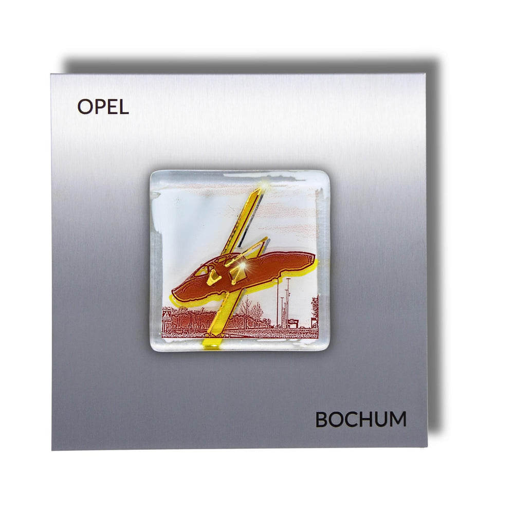 Edition 7/12. Pott Glas Wand-Potträt mit Opel Denkmal-Motiv in Gelb. Foto in Schmelzglas auf Edelstahl. Quadratisches Format mit Gravur „Opel Bochum“.