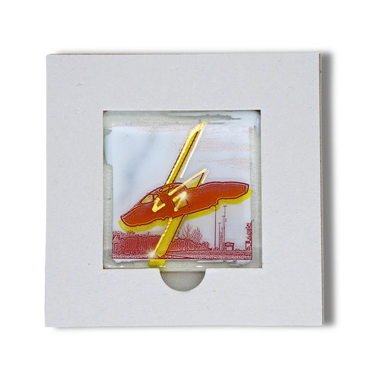 Bochum Edition 07/12. Offenes POTT GLAS Karten-Inlay mit quadratischer Aussparung und Entnahmeaussparung. Darin ein Magnet-POTTRÄT aus Schmelzglas mit gelbem Opel-GT-Denkmal-Motiv sowie Akzenten aus 24-Karat-Flüssiggold und Platin.