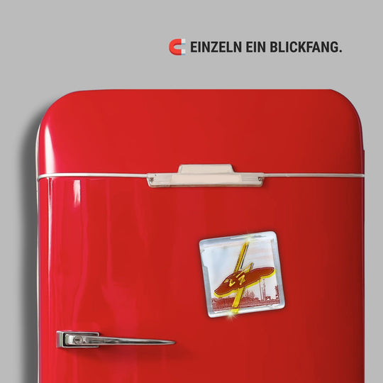 Bochum Edition 07/12. Zeigt das POTT GLAS Magnet-POTTRÄT „Opel“ in Gelb mit Gold- und Platinakzenten auf einem roten Retro-Kühlschrank. Hinweis: „Einzeln ein Blickfang“.