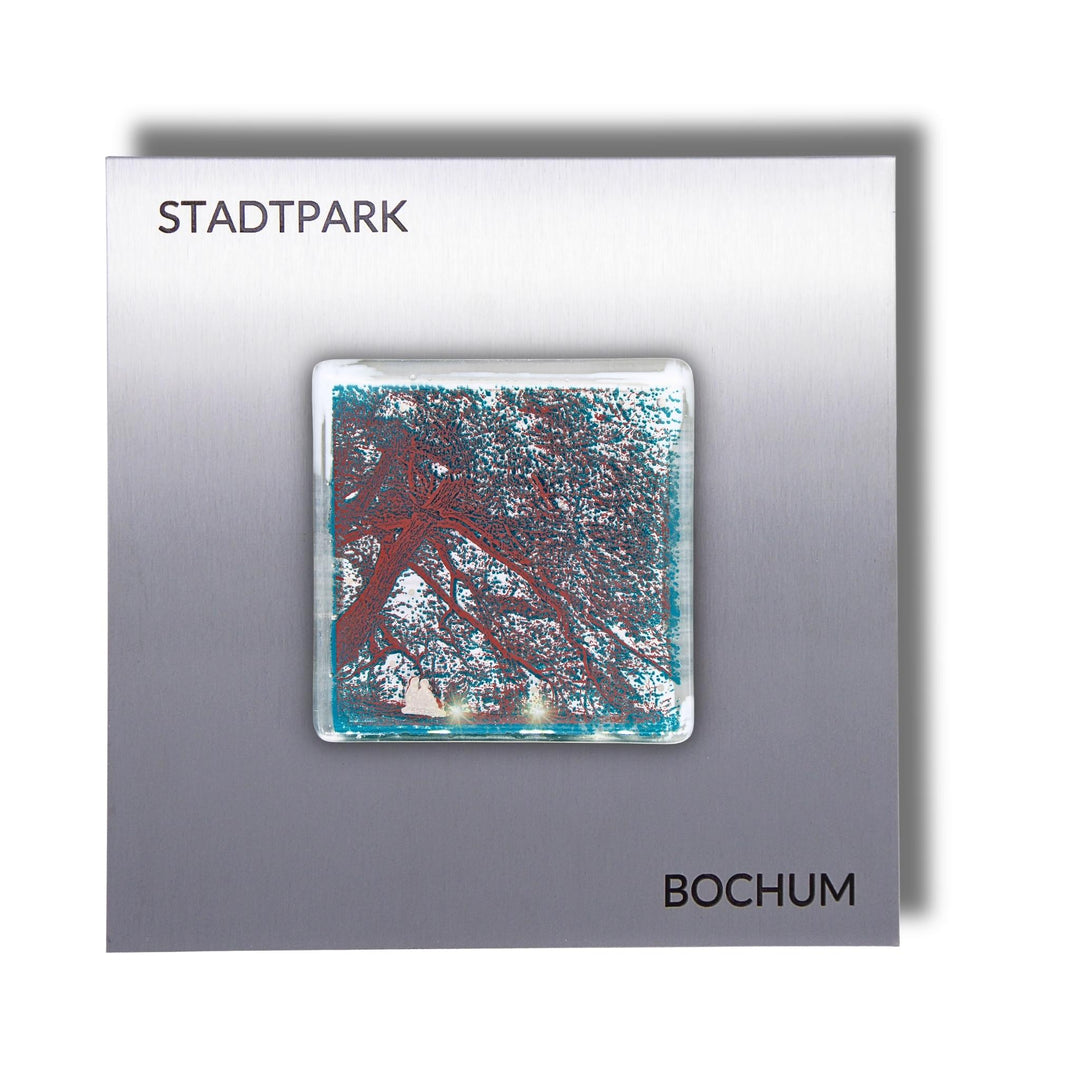 Edition 8/12. Pott Glas Wand-Potträt mit Stadtpark Baum-Motiv in Grün. Foto in Schmelzglas auf Edelstahl. Quadratisches Format mit Gravur „Stadtpark Bochum“.