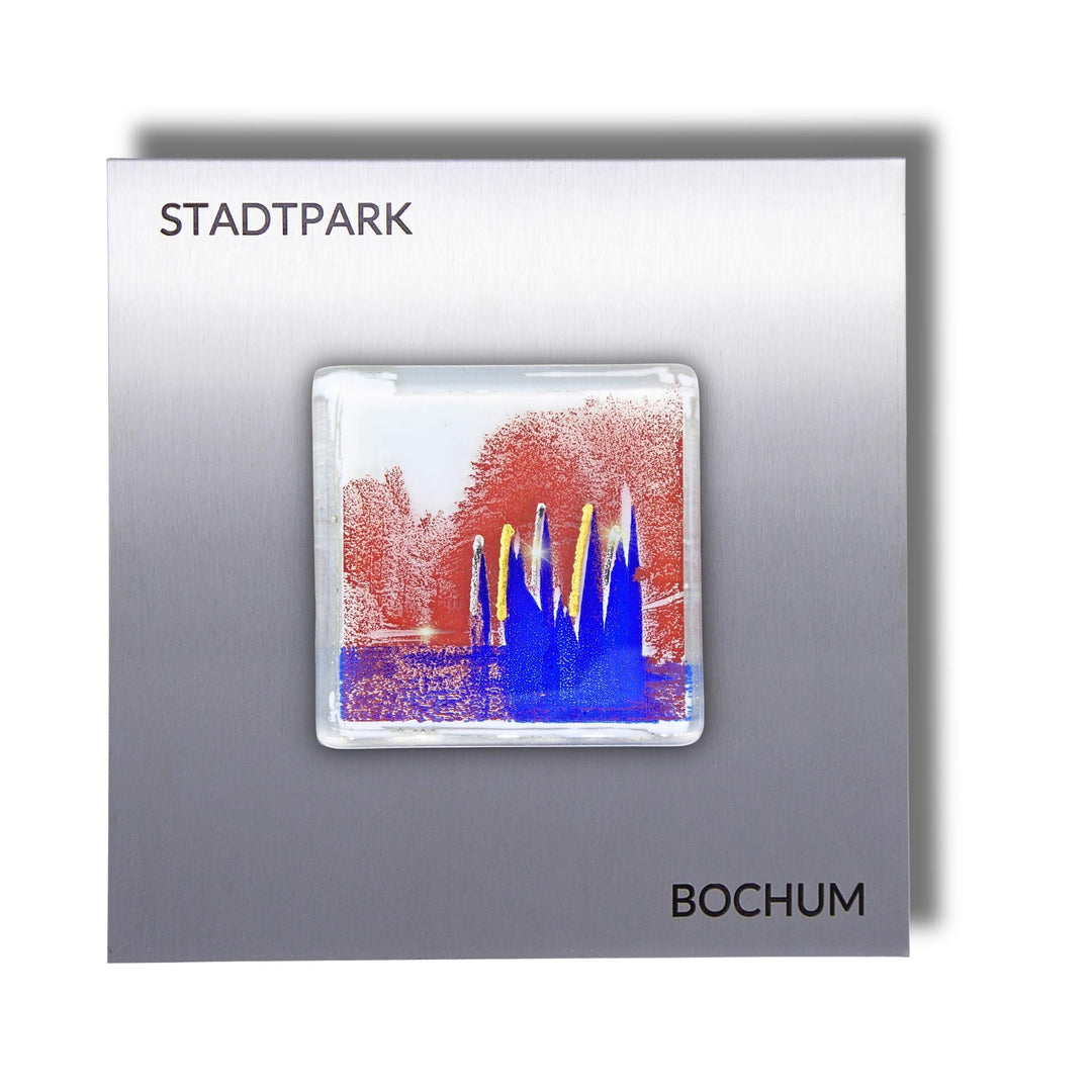 Edition 8/12. Pott Glas Wand-Potträt mit Stadtpark Fontäne-Motiv in Blau. Foto in Schmelzglas auf Edelstahl. Quadratisches Format mit Gravur „Stadtpark Bochum“.