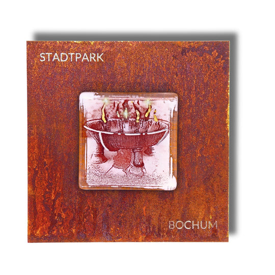 Edition 8/12. Pott Glas Wand-Potträt mit Stadtpark Feuerschale-Motiv in Rot. Foto in Schmelzglas auf Roststahl. Quadratisches Format mit Gravur „Stadtpark Bochum“.