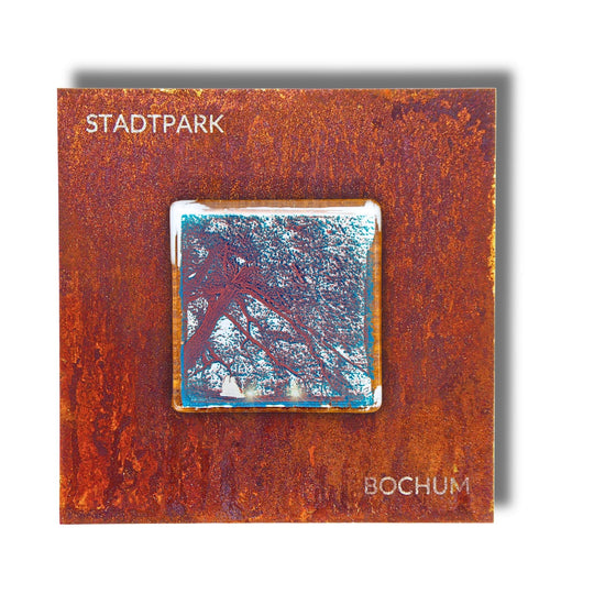 Edition 8/12. Pott Glas Wand-Potträt mit Stadtpark Baum-Motiv in Grün. Foto in Schmelzglas auf Roststahl. Quadratisches Format mit Gravur „Stadtpark Bochum“.