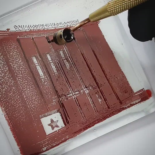 Pott Glas Produktvideo. Zeigt das manuelle Setzen von Akzenten am „Schauspielhaus“-Glasbild mit Flüssiggold und Platin.