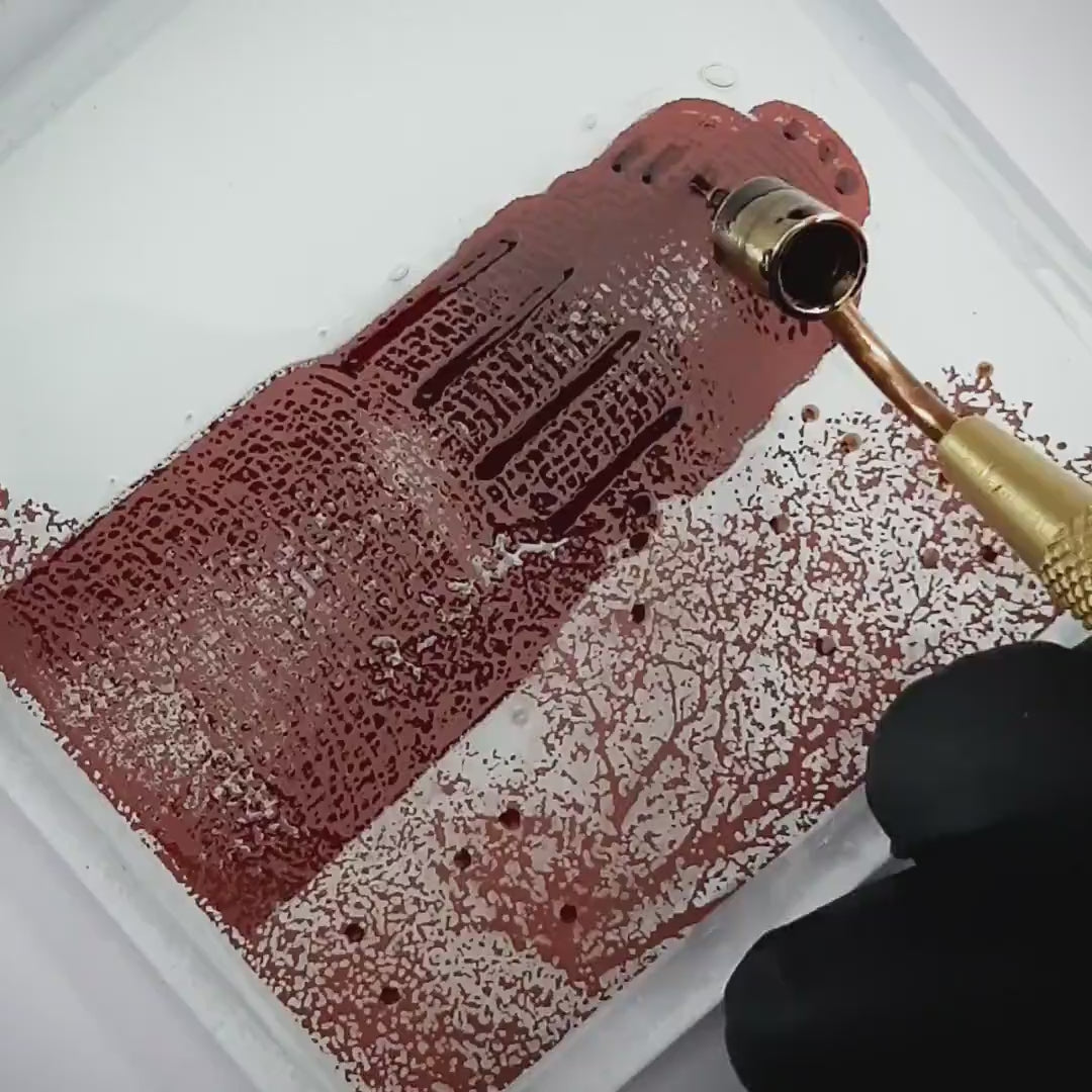 Pott Glas Produktvideo. Zeigt das manuelle Setzen von Akzenten am „Stadtpark“-Glasbild mit Flüssiggold und Platin.