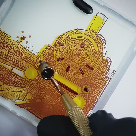 Pott Glas Produktvideo. Zeigt das manuelle Setzen von Akzenten am „Eisenbahnmuseum“-Glasbild mit Flüssiggold und Platin.
