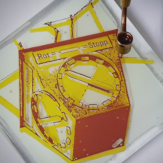 Pott Glas Produktvideo. Zeigt das manuelle Setzen von Akzenten am „Heuer-Ampel“-Glasbild mit Flüssiggold und Platin. Sichtbar sind gelbe, grüne, blaue und rote Motivvarianten.
