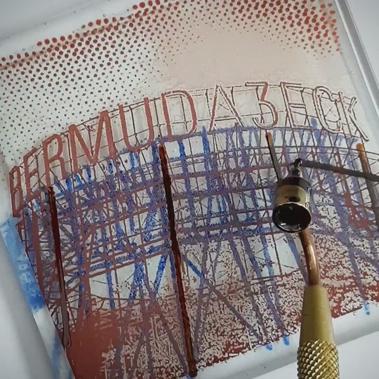 Pott Glas Produktvideo. Zeigt das manuelle Setzen von Akzenten am „Bermuda3eck“-Glasbild mit Flüssiggold und Platin.