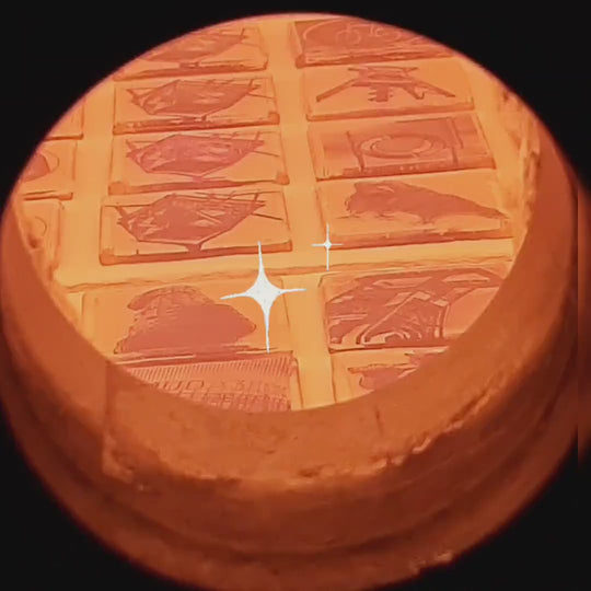 Pott Glas Produktvideo. Zweiter Edelmetallbrand. Blick durch das Guckloch in den Brennofen bei 770 °C. Ofenladung mit Bochum-Motiven.